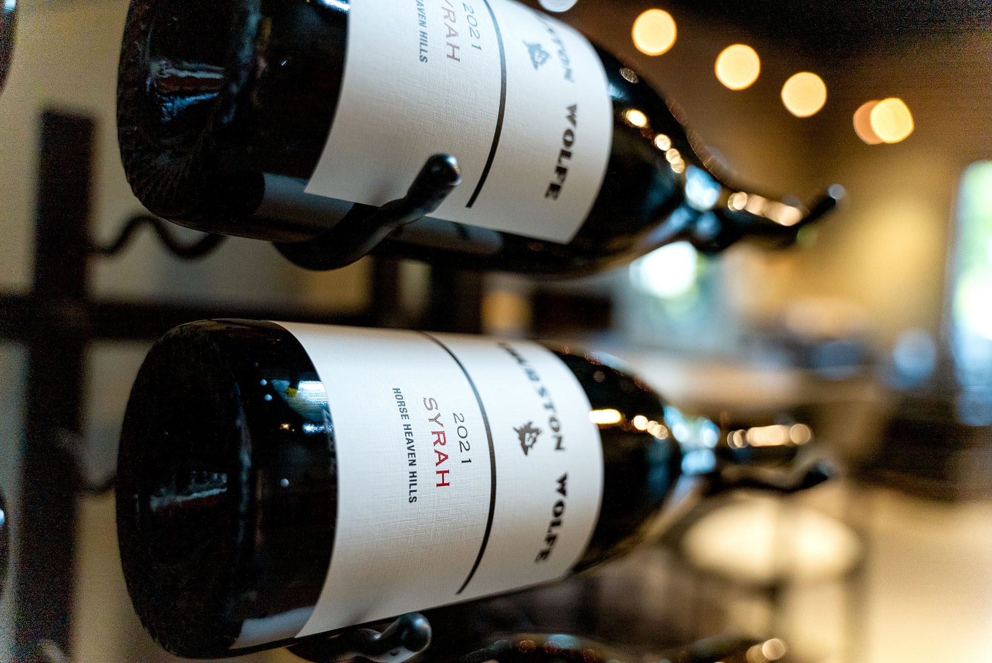 Wine bottles on a rack, blurred background.