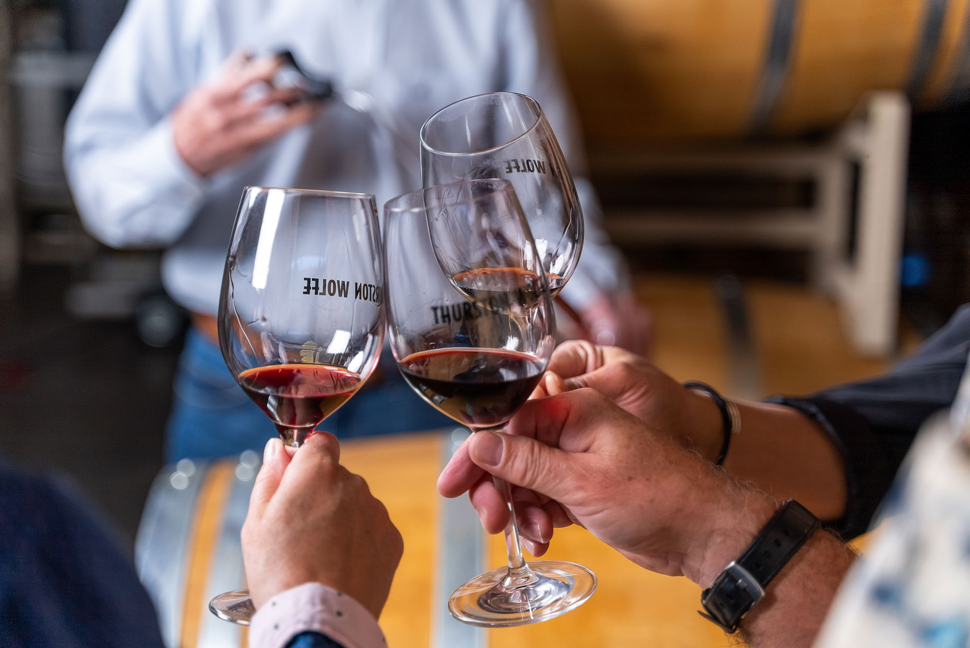 Three glasses of red wine in cheers.