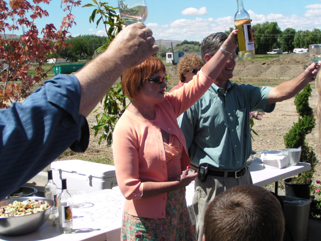 People toasting outdoors at a gathering event.