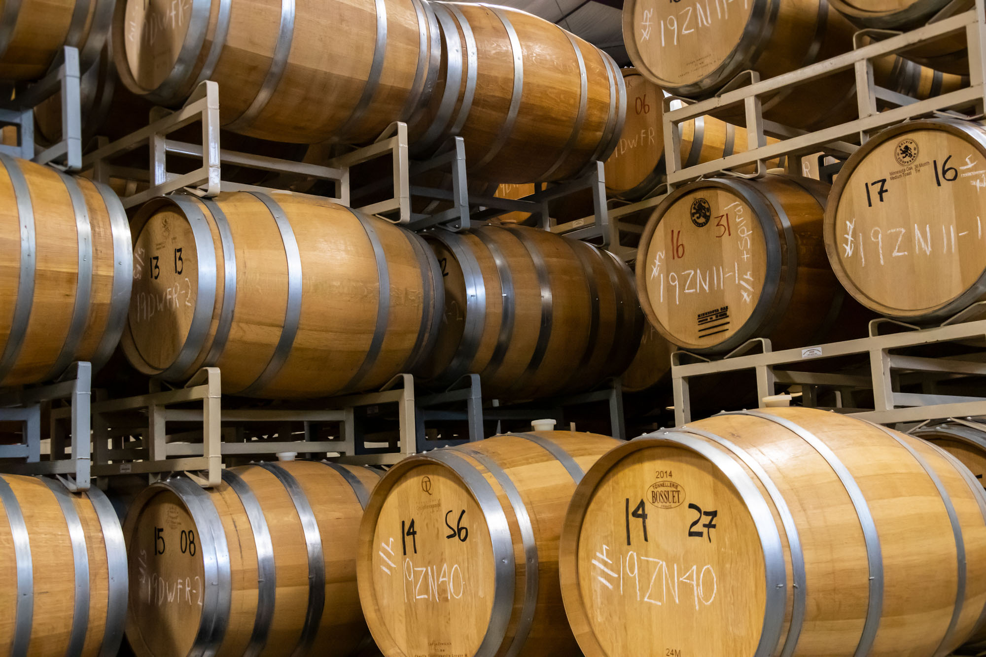 Stacked wooden barrels in a wine cellar.